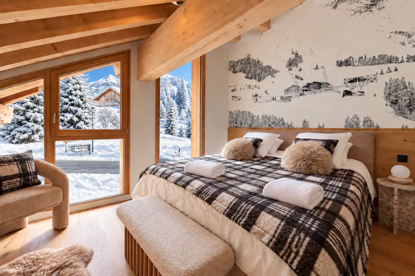 Chambre double avec plaid à carreaux et fenêtres sur la forêt enneigée