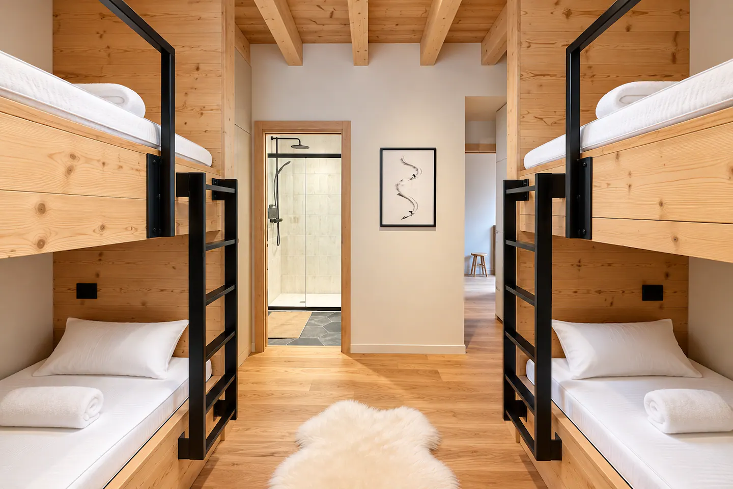 Chambre avec deux lits superposés en bois et métal noir